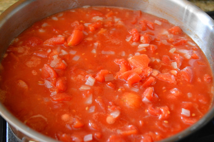 The diced onion and diced tomatoes simmering together as the base for the vodka sauce. 