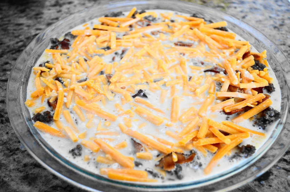 Then I layered the cooled beef mixture into my well greased pie dish, followed by the bacon, and lots of cheddar cheese on top. Lastly, I poured the Bisquick batter in slowly and let it seep into all of the little nooks and crannies to surround the filling. The bacon cheeseburger pie went in to bake at 400 for about 25 minutes. 