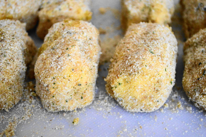 Then I formed that mixture into 8 little croquette cylinders. I dipped each of the potato croquettes in a beaten egg before coating them in breadcrumbs to finish forming them. 