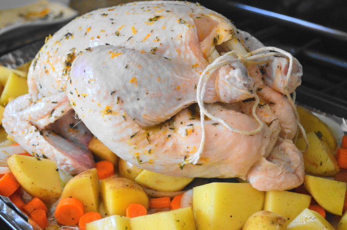 After I removed the giblets and rinsed my chicken, I patted it dry and placed it on top of the veggies. Then it was slathered in that gorgeous mixture. Lastly, I tied the legs together with kitchen twine to keep everything in a tight package. 