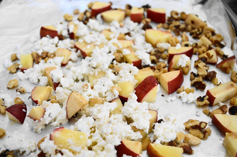 First, I spread my diced apple and chopped walnuts out on a lined sheet tray. I wanted them to just get toasty for about 5 minutes in the oven. When the tray came out, I let it cool for a minute before I crumbled the goat cheese on it. That allowed the goat cheese to warm up without melting! 