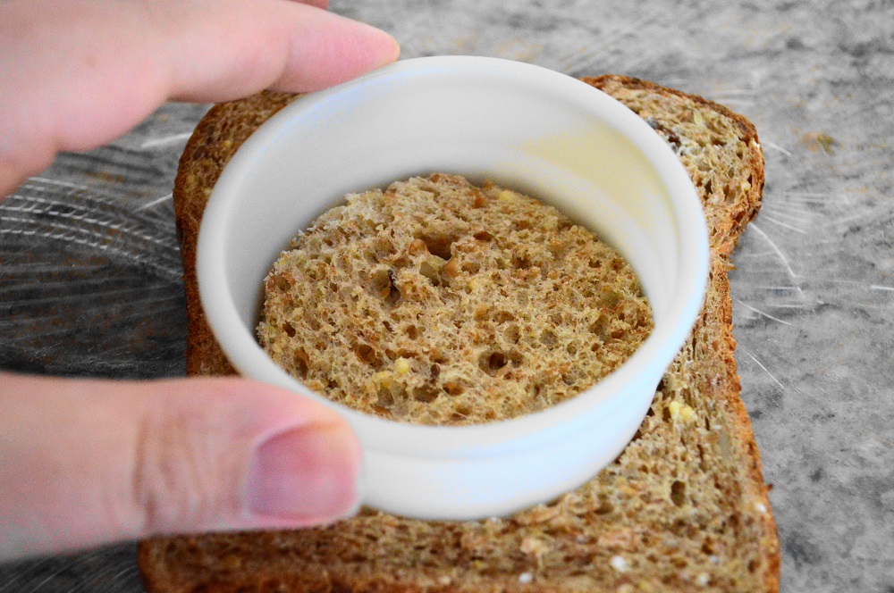 Then I used a 2.5 inch biscuit cutter to get the perfect sized holes in my two bread slices. That was one of the keys I learned in making these babies. If the hole was too small the egg wouldn't cook through properly before the bread was burned. If it was too big, the egg was overcooked before the bread could get perfectly toasted. 