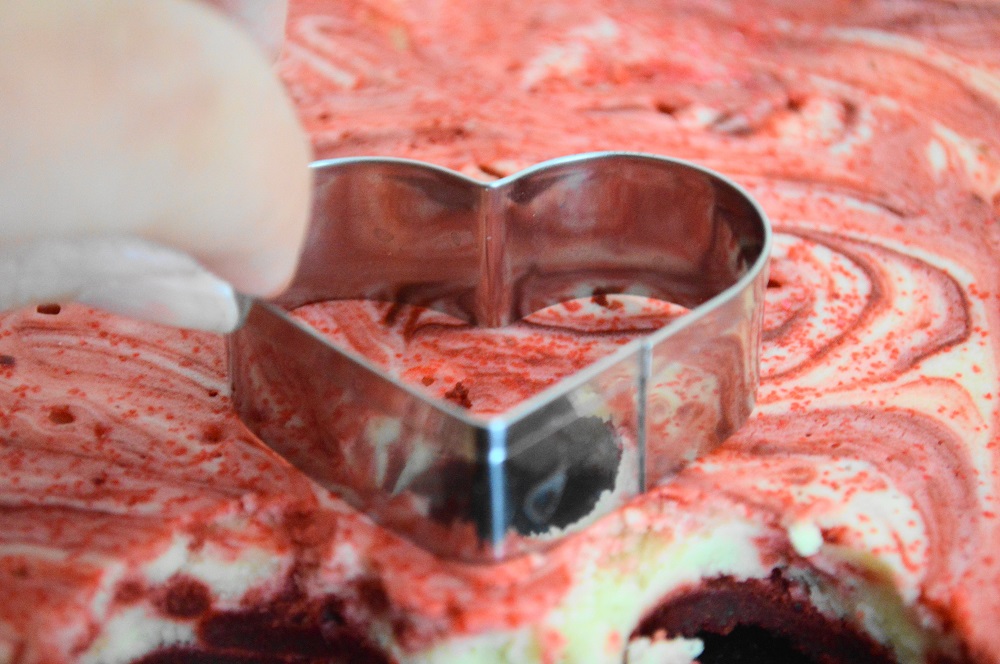 Once it had chilled, it was time to cut out the red velvet cheesecake hearts! I ran my heart shaped cutter under the hottest water I had, then dried it with a paper towel. That helped to cut through the cheesecake cleanly. I cut them out as close together as possible to minimize scraps. I loved snacking on the scraps as I worked! Hubby had some too as part of my highly technical quality control. 