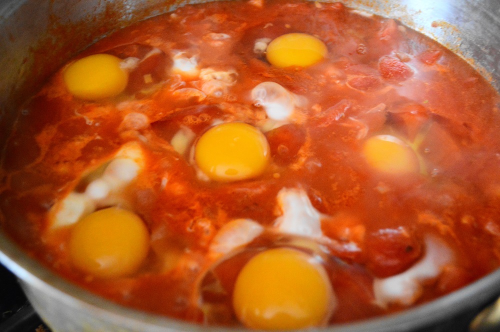 Then it was time for the eggs to go into their purgatory bath. I cracked them into their own little individual bowls first. That helped me make sure the yolks didn't crack. I could just slide them in gently from the bowl on top of the purgatory sauce. 