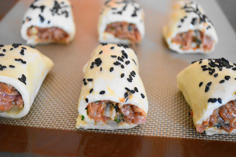 Ho arrotolato quella pasta sfoglia strettamente intorno al ripieno di salsiccia per ciascuno dei 6 rotoli di salsiccia australiani che ho fatto. Poi li ho finiti con un lavaggio delle uova e una generosa spolverata di semi di sesamo nero in cima. Ogni rotolo è stato tagliato in 6 pezzi, che li ha resi perfetti per un morso partito. 