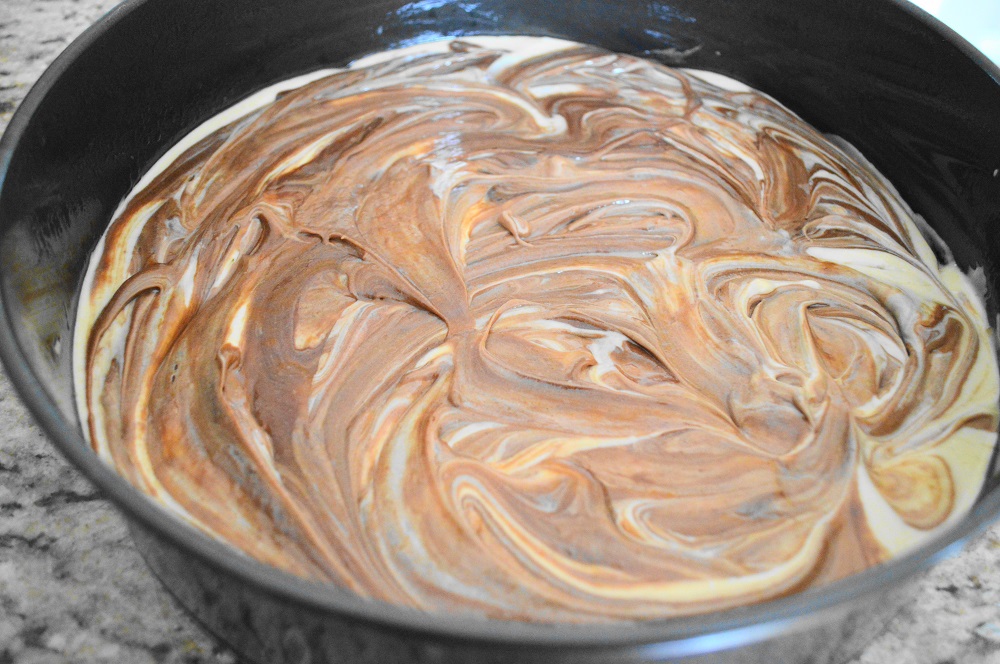With the three main components made, it was time to assemble and bake the chocolate peanut butter cheesecake! I poured the cheesecake batter in first. Then I drizzled the batter in on top of it and swirled it in gently with a butter knife. It needed to bake for about 35 to 40 minutes to get puffy and baked through without cracking on top. 