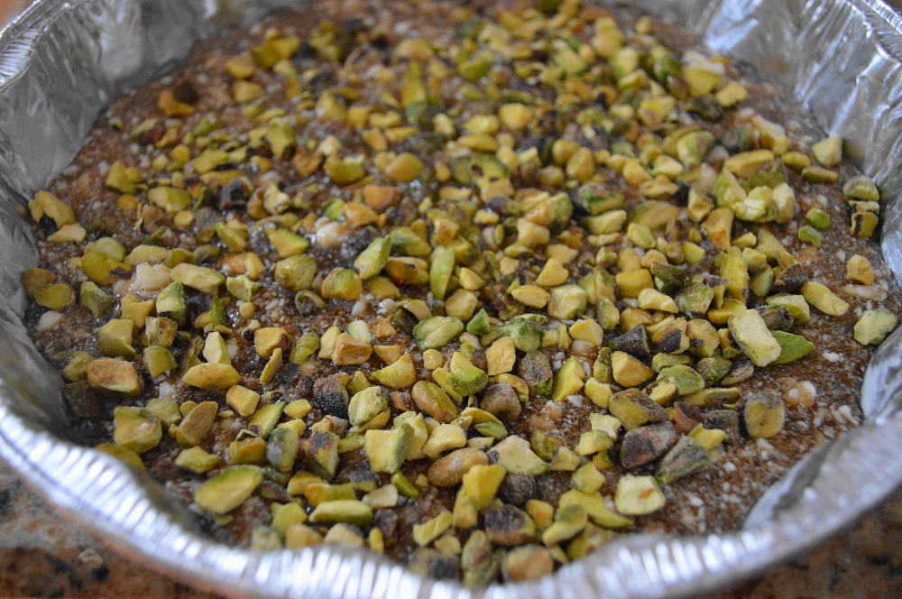 I used two 9 1/2 inch pie pans that were nice and deep to hold that lovely glaze. Then I sprinkled a generous layer of chopped pistachios on top of that glaze to get the pans prepared. 