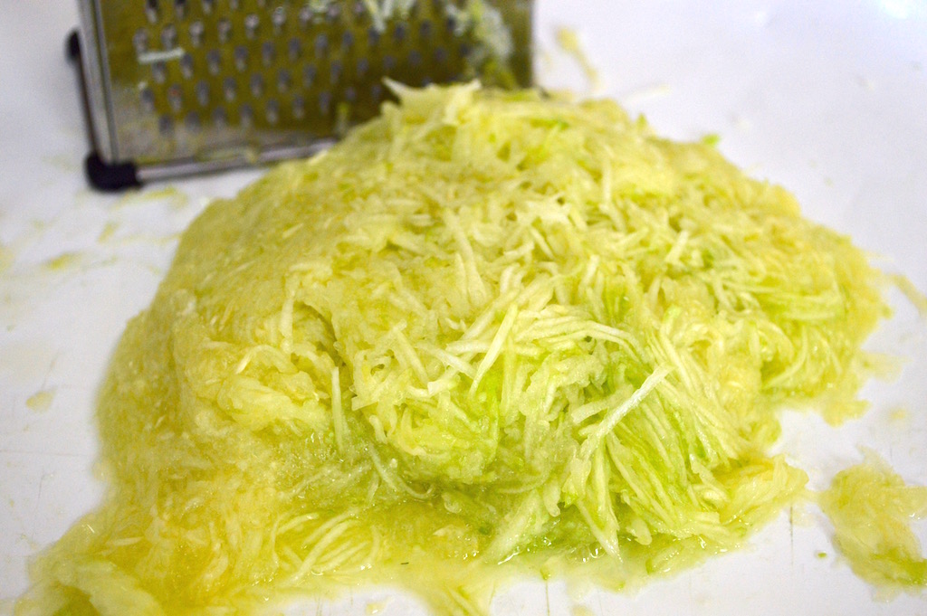 The first step to my mom's zucchini bread was to peel and grate two zucchinis. I grated them really finely on the smallest holes of my box grater so that it would give the bread some texture without it being too chunky. Since mine was particularly watery I blotted it with a paper towel too. 