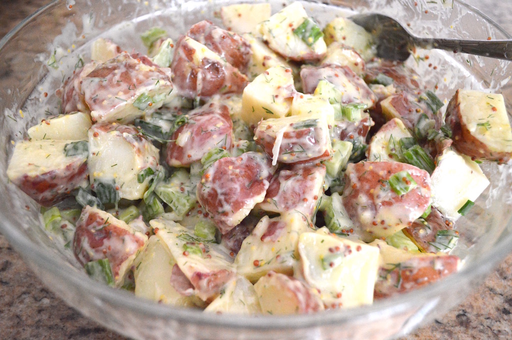 When the potatoes were cool enough to handle after their steamy spa treatment, I cut them all in half, then cut each half into quarters to make manageable wedges. Then I tossed them with the aromatics and dressing to finish the potato salad up! I let it chill for 3 hours or so before serving with dinner. 