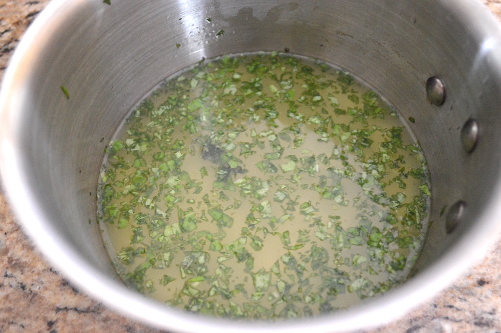 I made sure to pour lots of lemon juice through a fine mesh strainer to catch any stray seeds or bits as it went into my small pot. Then I added sugar, finely chopped basil and a little rum for big flavor. It just needed to warm up just enough over medium heat to dissolve the sugar. That was all there was to making the mixture for the lemon basil granita!