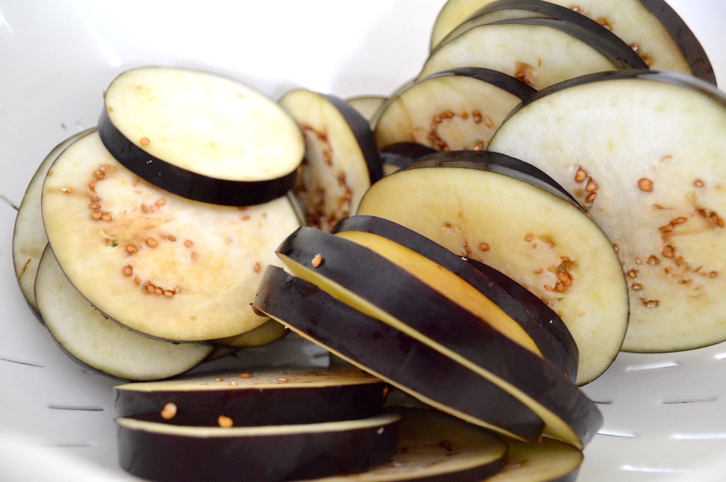 While the sauce simmered, I prepared the eggplant. The first and very important step was to generously salt the eggplant slices and let them sit in my colander in my sink. This drew out some of the moisture and bitterness from it, which was essential. It kept the eggplant parmigiana from getting soggy and too bitter. 