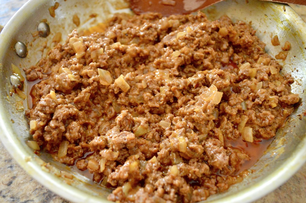 The filling for the cheeseburger egg rolls came together quickly. I browned up ground beef with lots of onion and seasoning. Crushed red pepper gave it a fantastic kick! Then I just stirred in lots of extra sharp cheddar cheese. It made the mixture so flavorful and held it together as it melted in! 