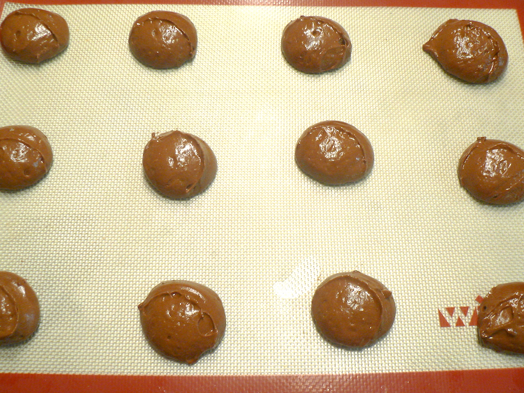 The half moon cookies laid out on the cookie sheet. 
