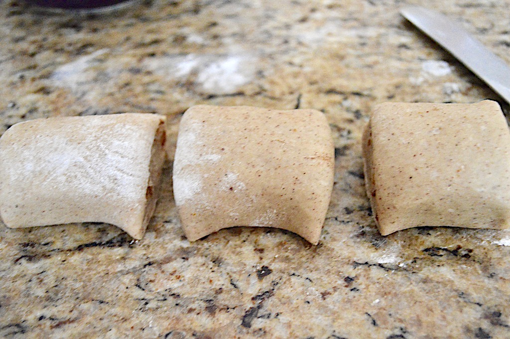 Soon enough it was time to form the gingerbread sticky buns. I rolled out half of the dough into a big, thin rectangle. Then I buttered it liberally and sprinkled it with loads of sugar and spice. I rolled that rectangle into a tight log and cut it into 12 equal pieces. 