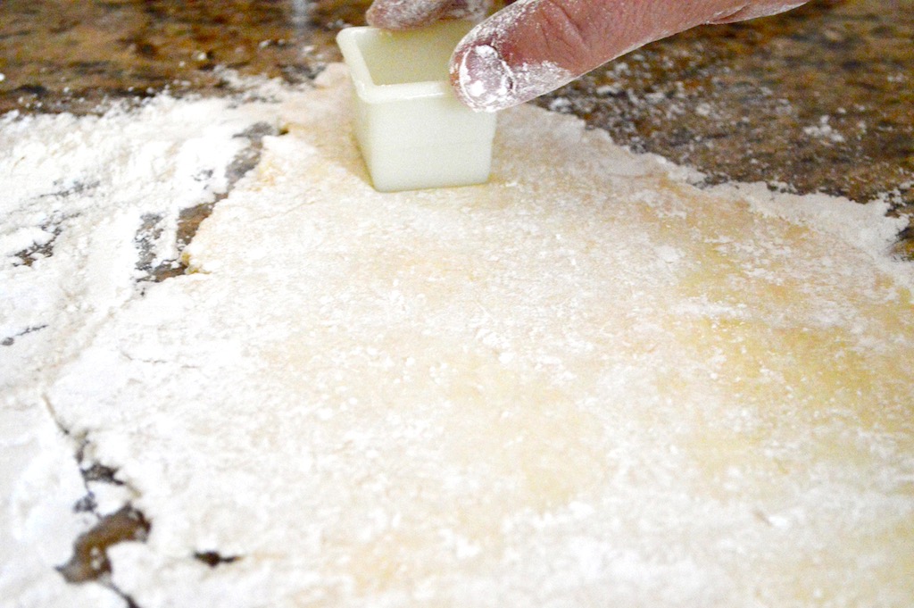 From there making the Polish kiffles became a two person operation. Hubby and I both got to work rolling out and cutting out the dough into perfect little squares using my square cutter. 